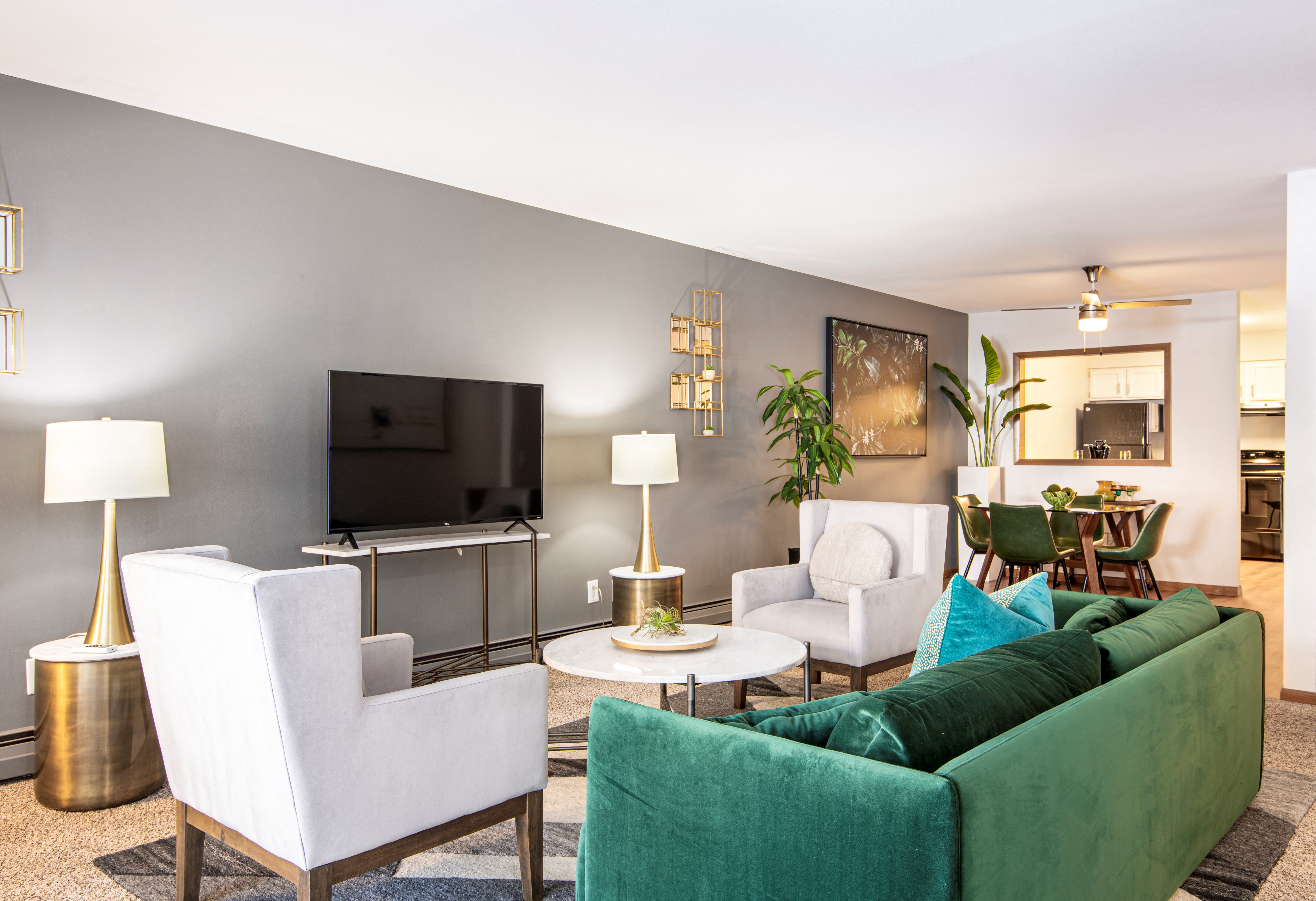 a living room with a couch and chairs and a television